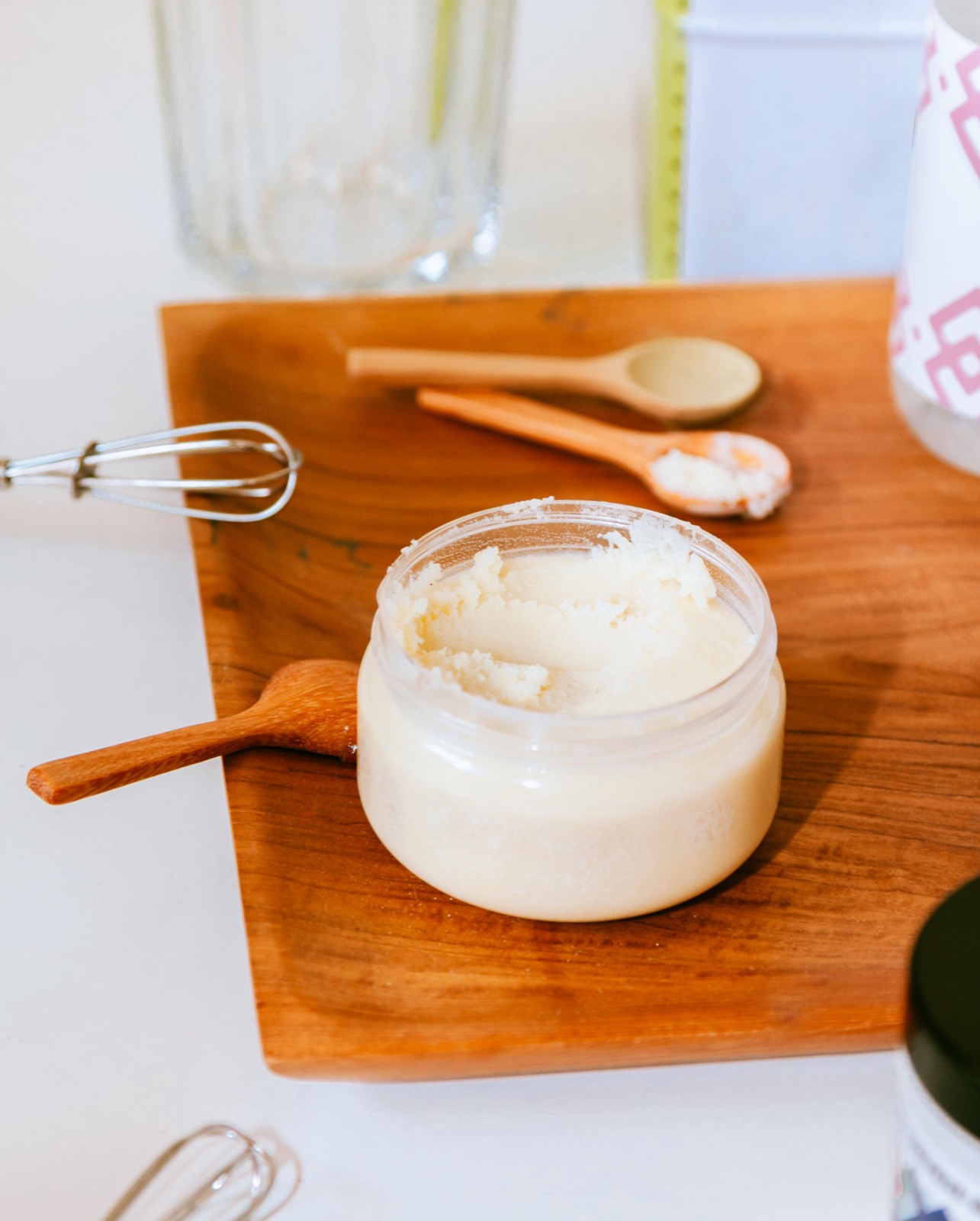 An open jar of butter on wood